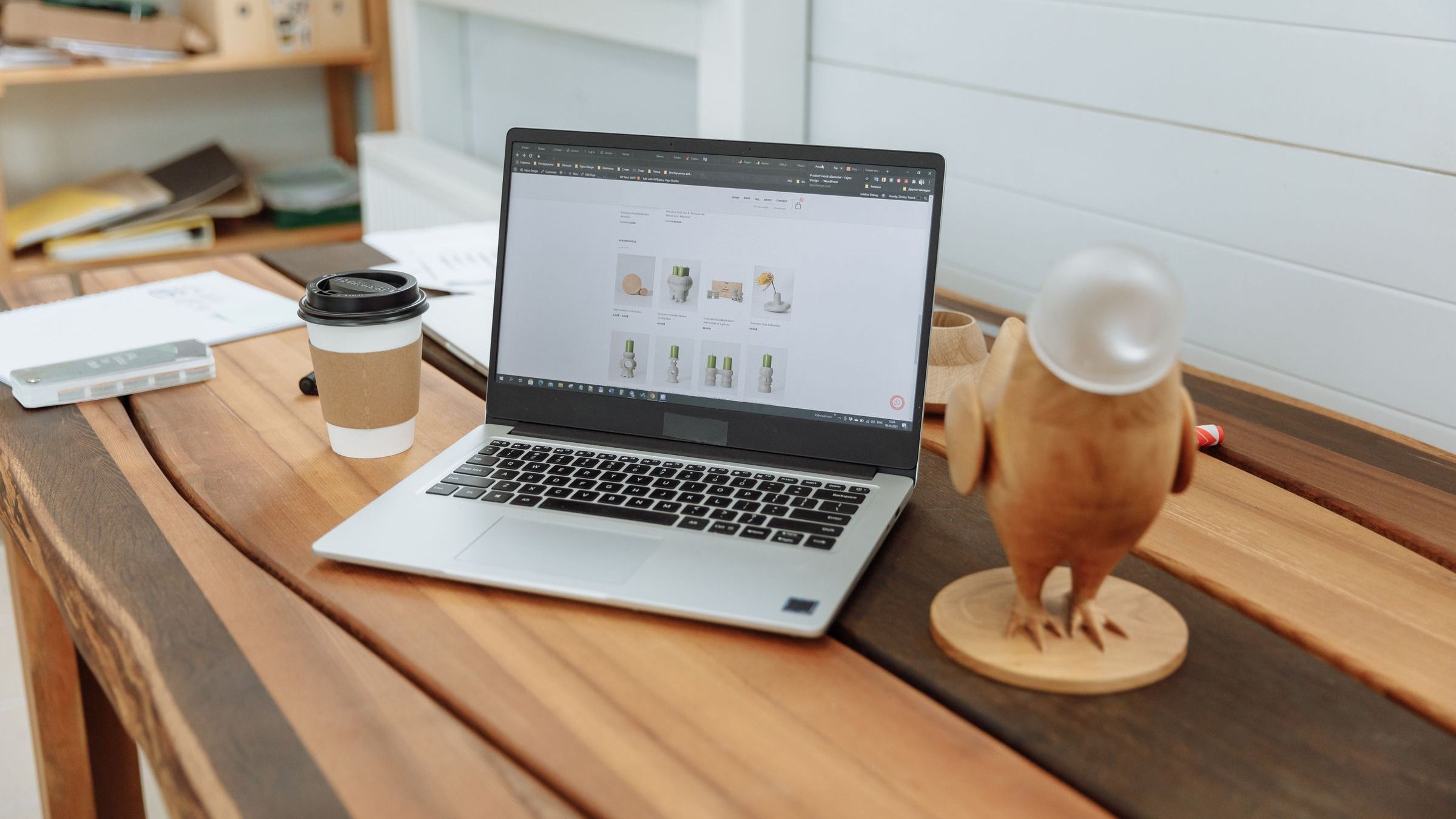 Een laptop met een website op het scherm, op een houten bureau.